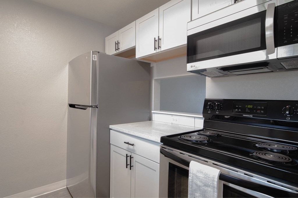 A kitchen with white cabinets and a black stove top oven.