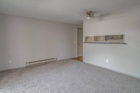 Empty room with a ceiling fan and a radiator on the wall.