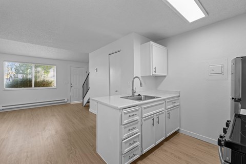 A kitchen with white cabinets and a black stove top oven.