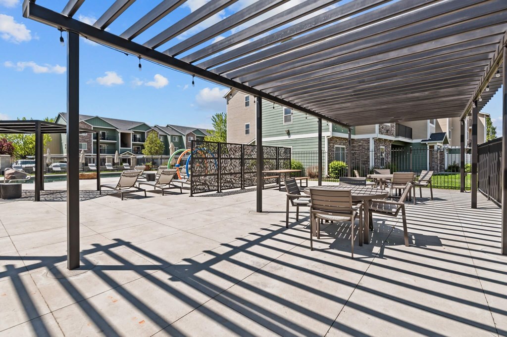 A patio with a table and chairs under a roof.