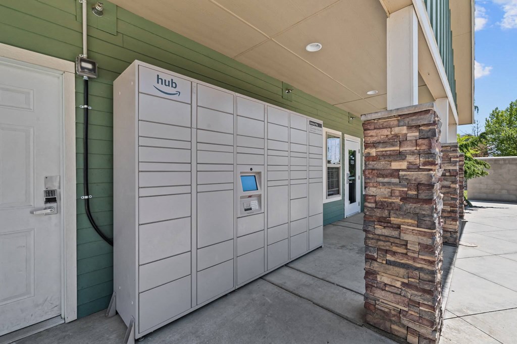 A row of white refrigerators are lined up outside a green building.