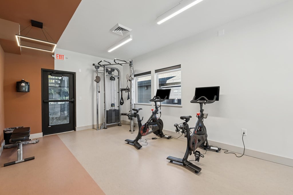 A gym with exercise equipment and a television.