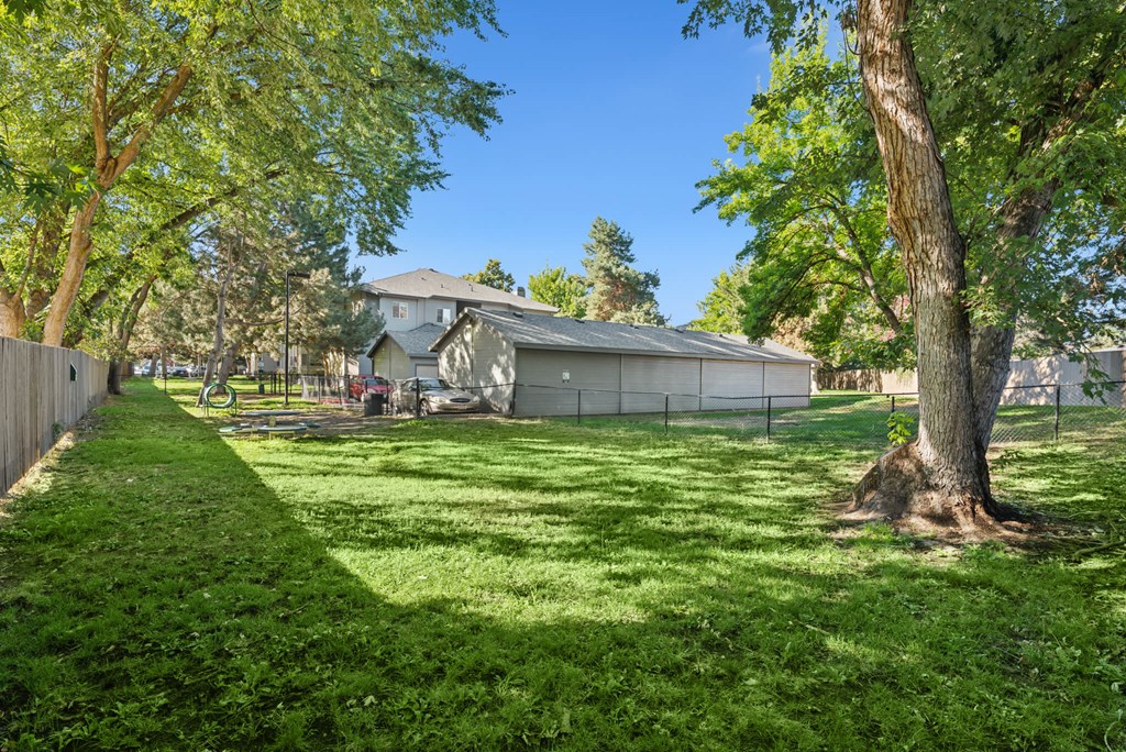 A house with a fence and trees in front of it.