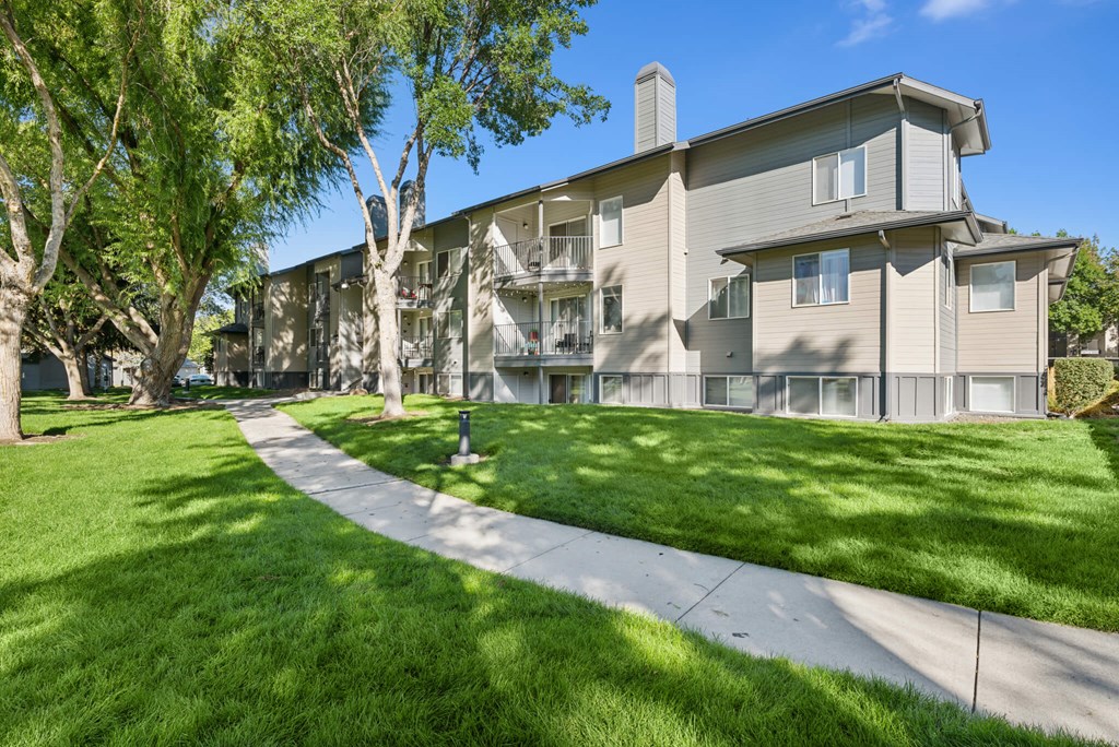 Apartment complex with a walkway in front.