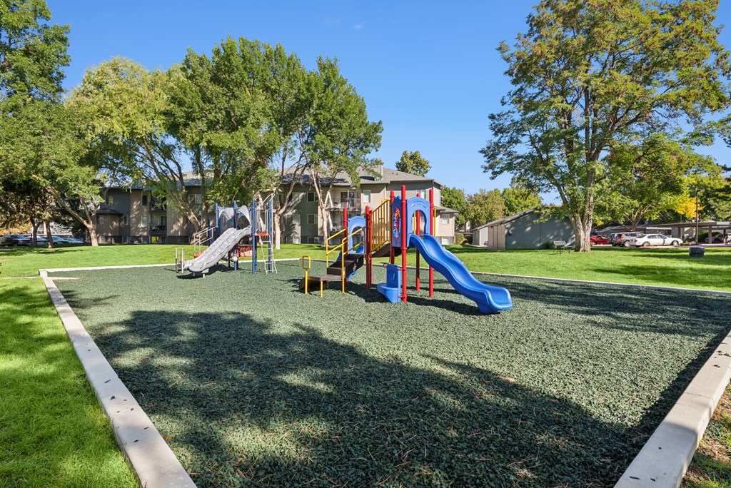 A playground with a blue slide and a red and yellow slide.