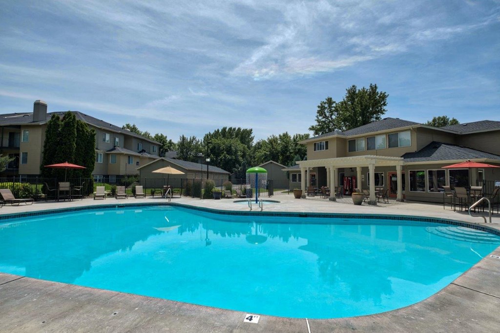A large swimming pool in front of apartment buildings.