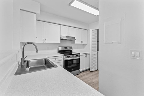 A kitchen with white cabinets and appliances.