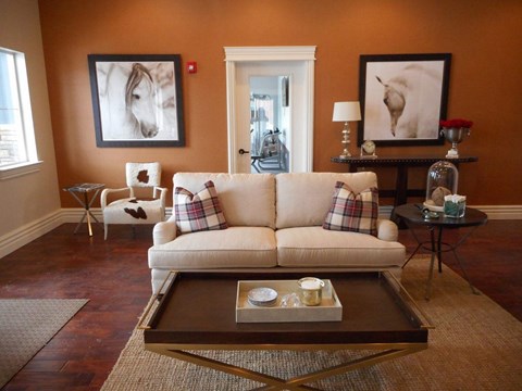 A living room with a couch, coffee table, and two framed pictures on the wall.