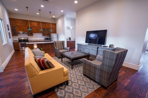 A living room with a yellow couch and a grey chair.