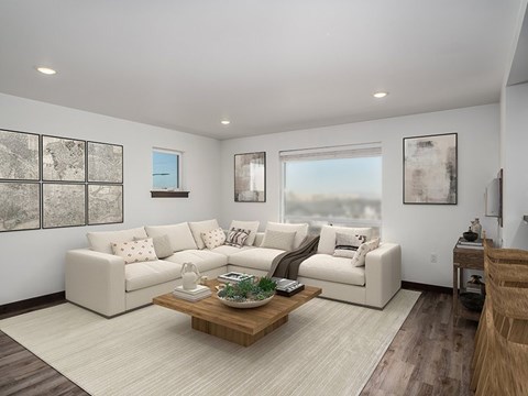 A living room with a white couch, a coffee table, and a painting on the wall.