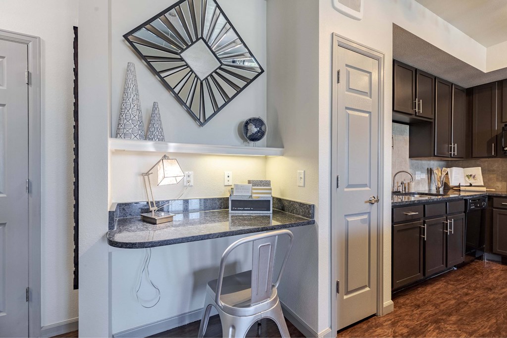 A kitchen with a white chair and a marble counter.