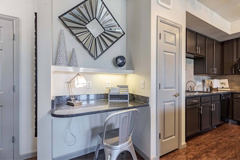 A kitchen with a white chair and a marble counter.