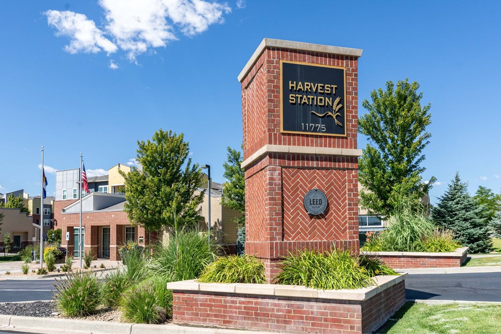 A brick pillar with a sign that says Harvest Station.
