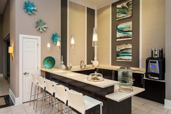 A kitchen with a white counter and chairs.