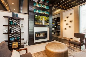 A modern living room with a fireplace and a large painting on the wall.