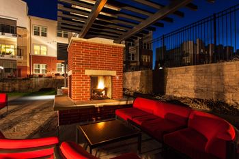 A patio with a fireplace and red couches.