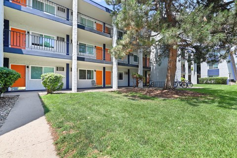 Apartment community courtyard with large trees and bike parking at Peaks on Drake Apartments, Colorado