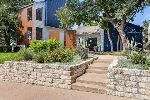 Contemporary home exterior with stone walkway and drought tolerant plantings at Peaks @ NW Hills Apartments, Austin
