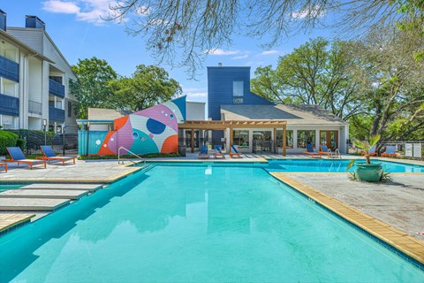 Turquoise pool with wooden decking and pergola covered patio at Peaks @ NW Hills Apartments, Austin