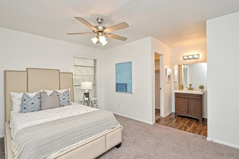A bedroom with a bed, dresser, and mirror.
