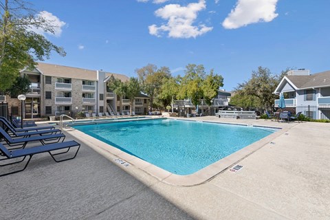 Large swimming pool with sun deck and lounge seating at Polo Club Apartments, Texas