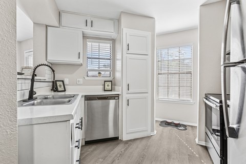A kitchen with white cabinets and stainless steel appliances.