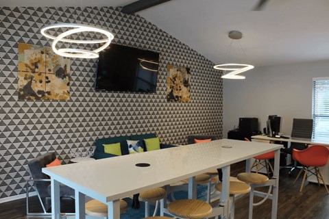 Collaborative workspace with conference table and computer stations at Peaks at Live Oak Apartments, Texas