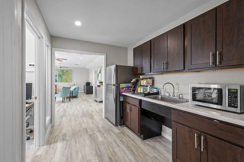 A kitchen with brown cabinets and a black refrigerator.