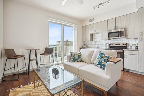A modern living room with a white couch and a glass coffee table.