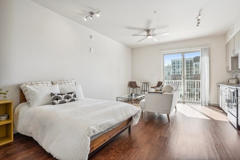 A bedroom with a large bed and a ceiling fan.