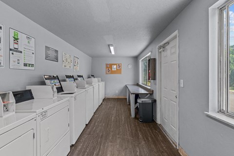 A laundromat with washers and dryers lined up on the left.