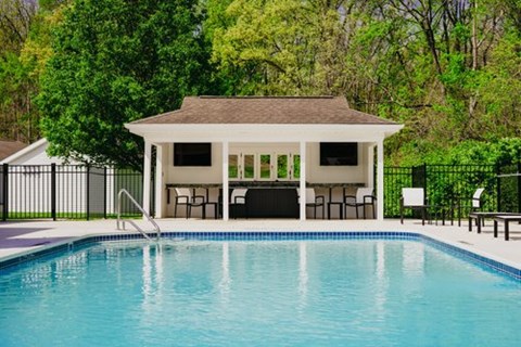 A pool with a pavilion in the background.