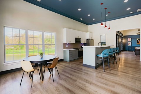 A kitchen with a table and chairs in front of a window.