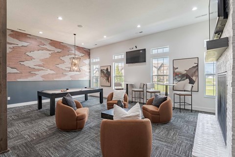 A modern living room with a grey carpet and a large painting on the wall.