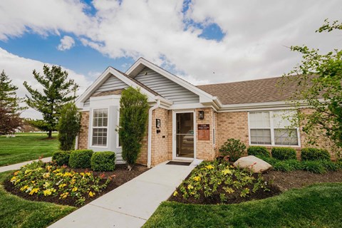 A house with a front yard and a walkway leading to the front door.
