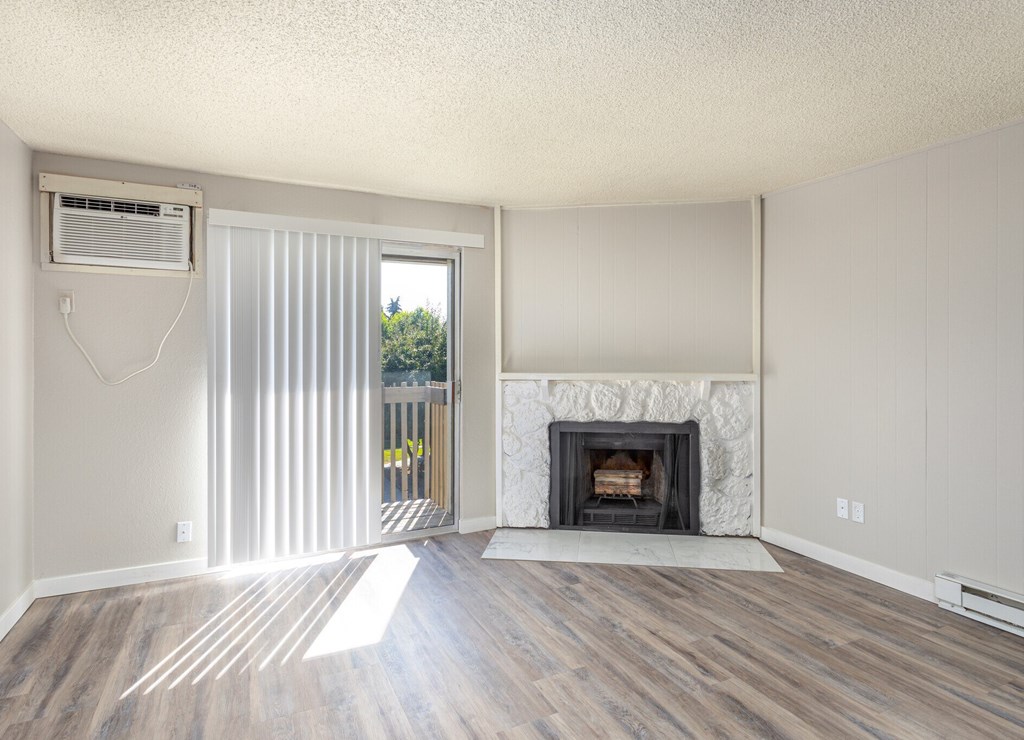 A room with a fireplace and sliding glass doors.