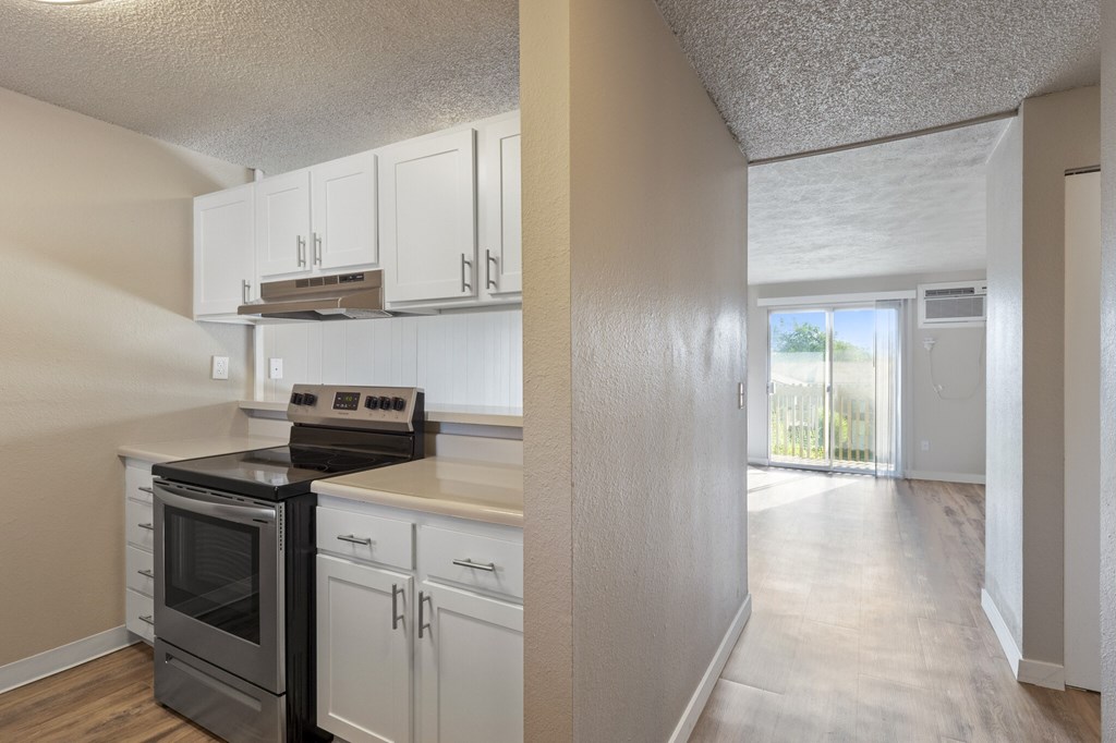 A kitchen with white cabinets and a black stove top oven.