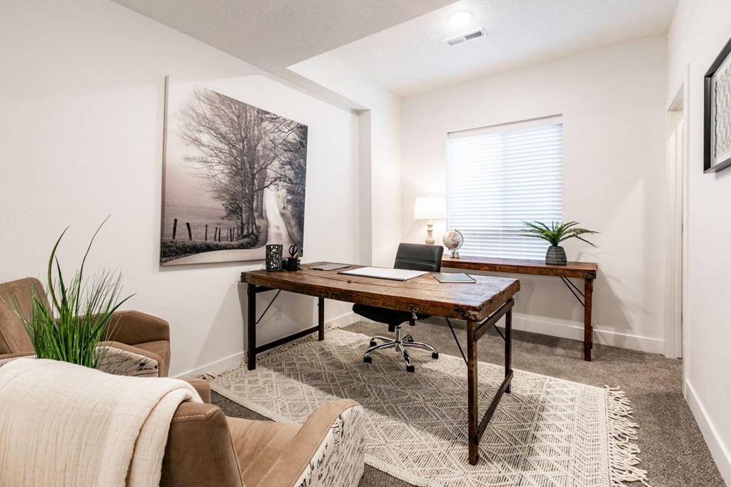 a home office with a desk and a window