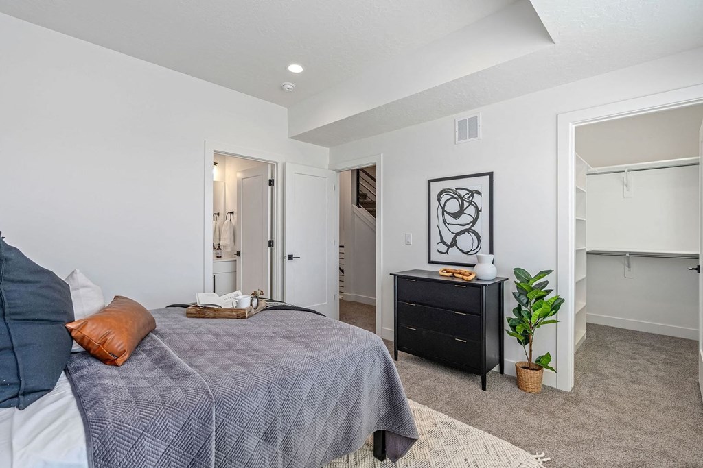 a bedroom with a bed, a dresser, and a closet