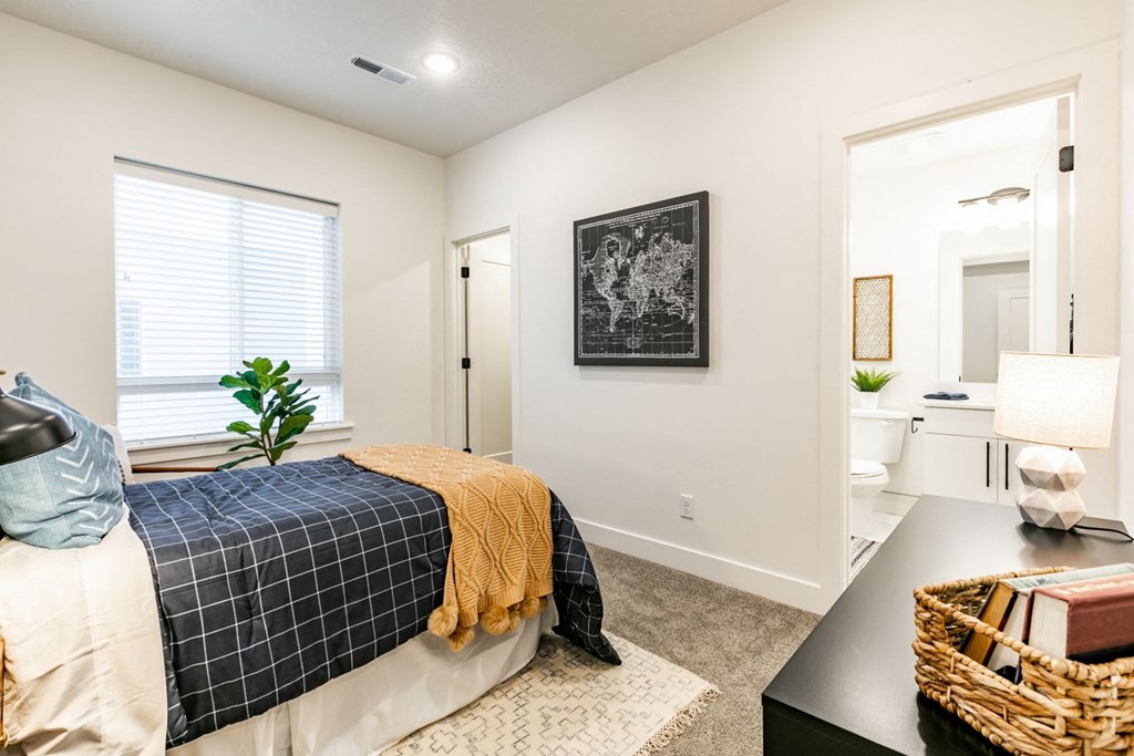 a bedroom with a bed and an open door leading to a bathroom