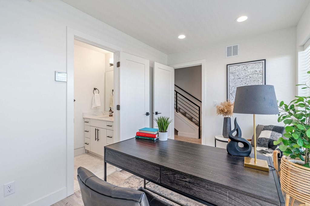 a home office with a desk and a door leading to a staircase