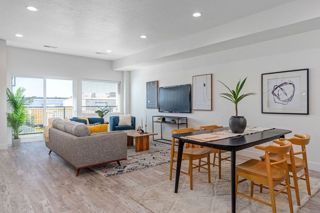 a living room and dining room with a table and chairs
