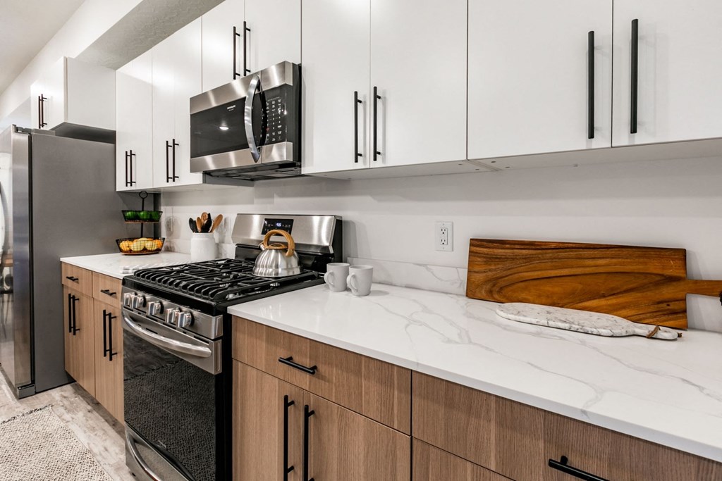 a kitchen with white cabinets and a stove and a microwave