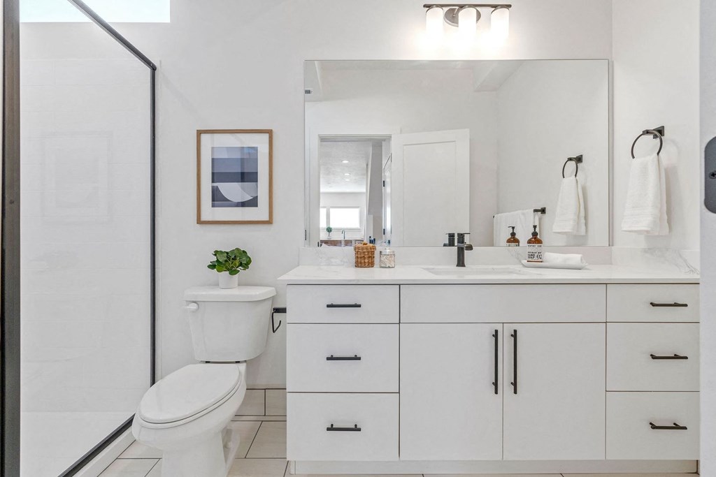 a white bathroom with a toilet and a sink