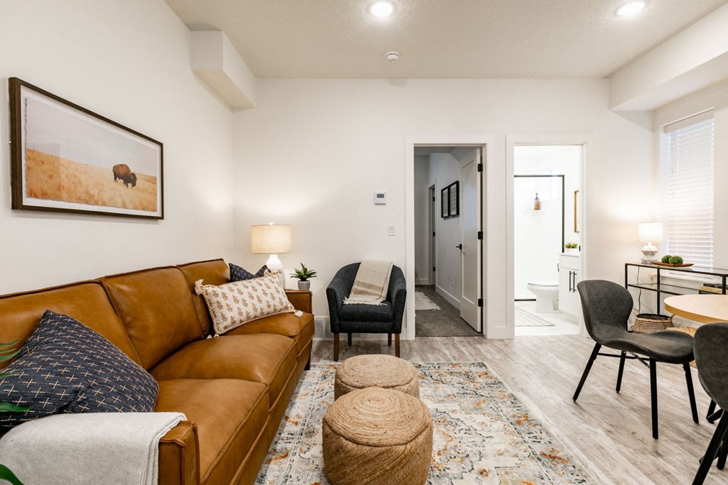 a living room with a brown couch and a dining room table