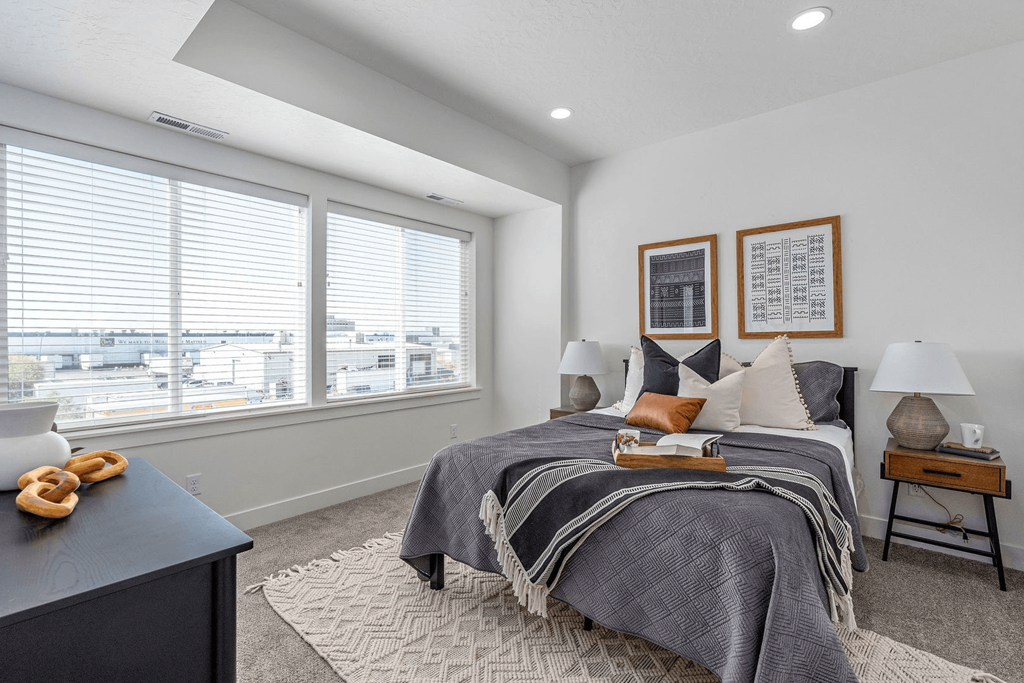 a bedroom with a bed and two windows