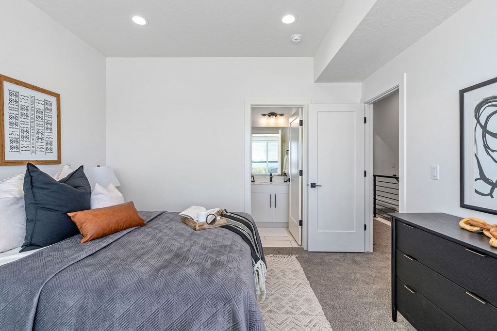 bedroom with a bed and dresser and a door leading to a bathroom
