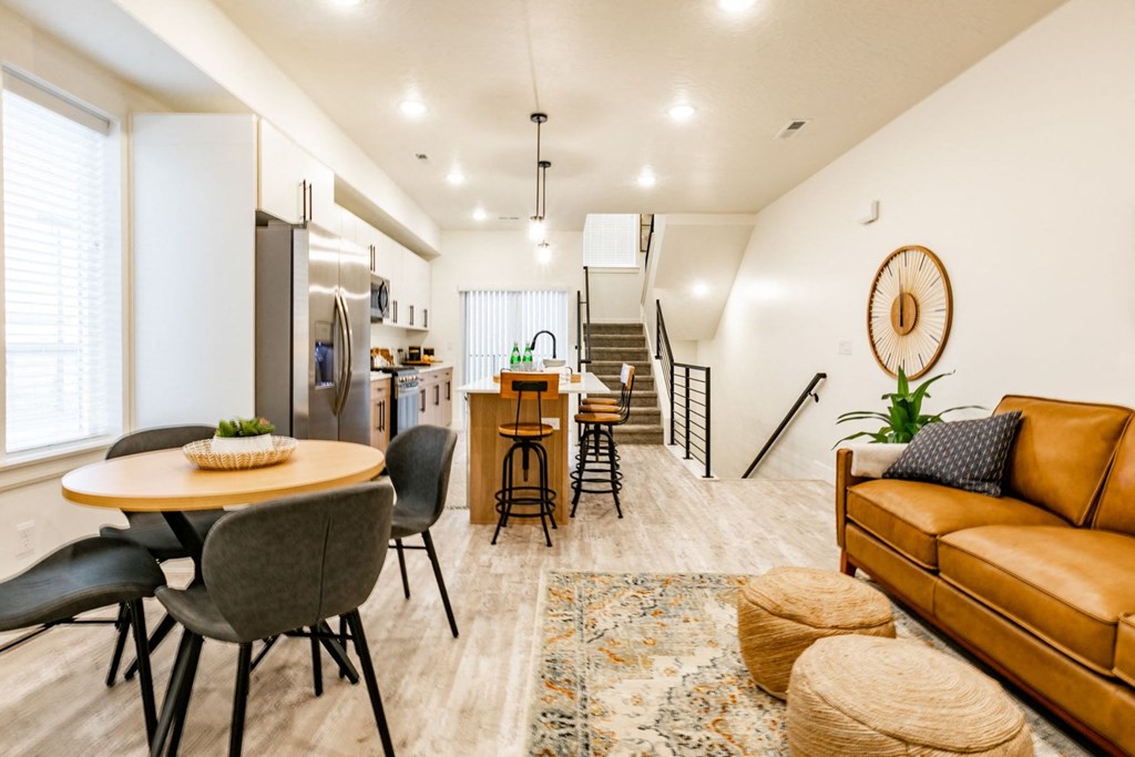 a living room with a table and chairs and a kitchen