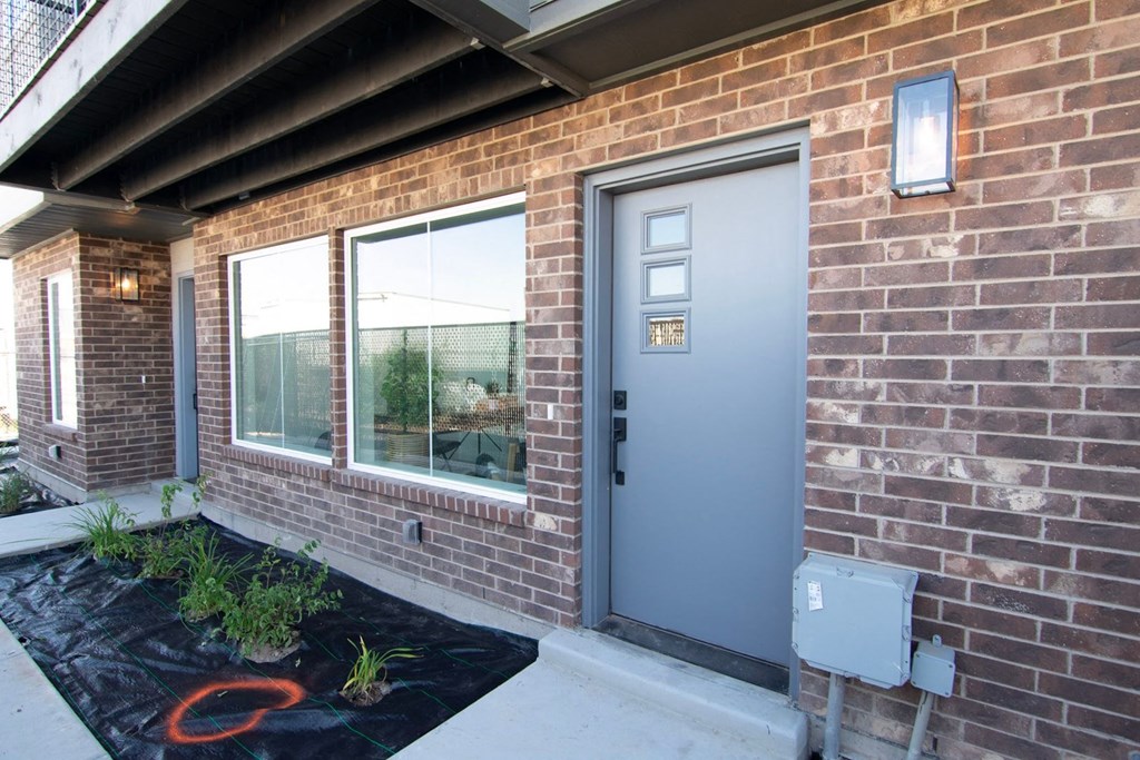 front door of unit with windows and brick front