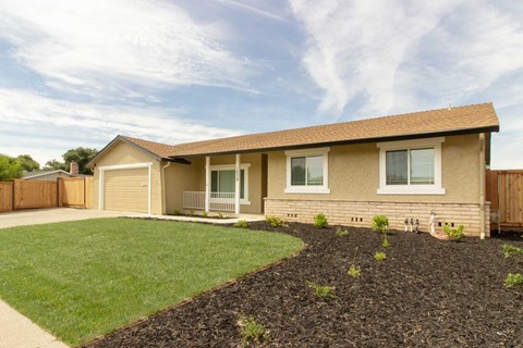 A house with a brown roof and a grey garage door.